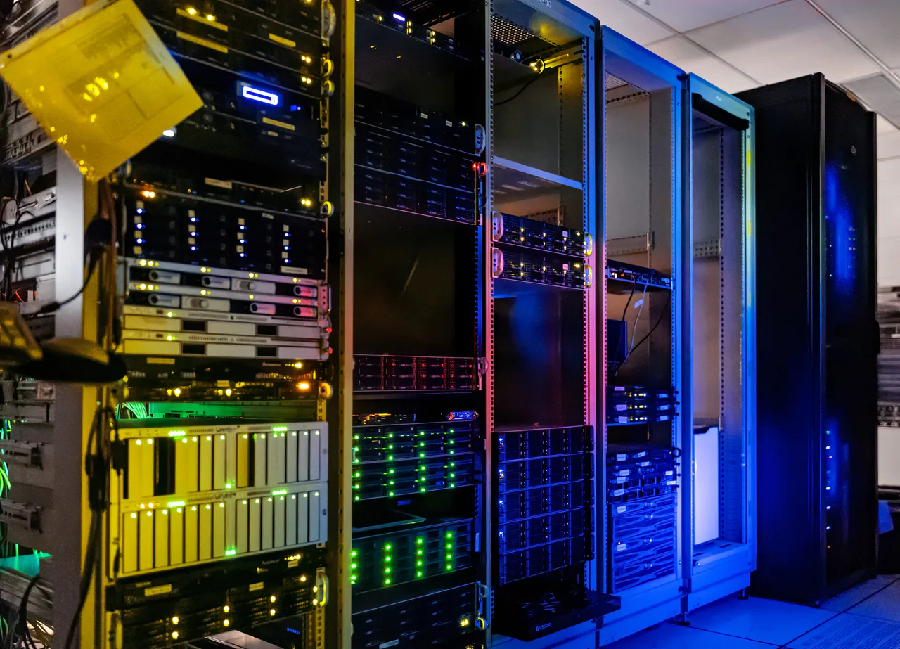 Illuminated server racks containing cabling and computing equipment.