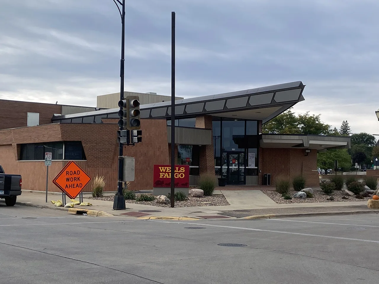 Entrance to the Wells Fargo bank building in Austin, Minnesota, with a brick facade and red sign.