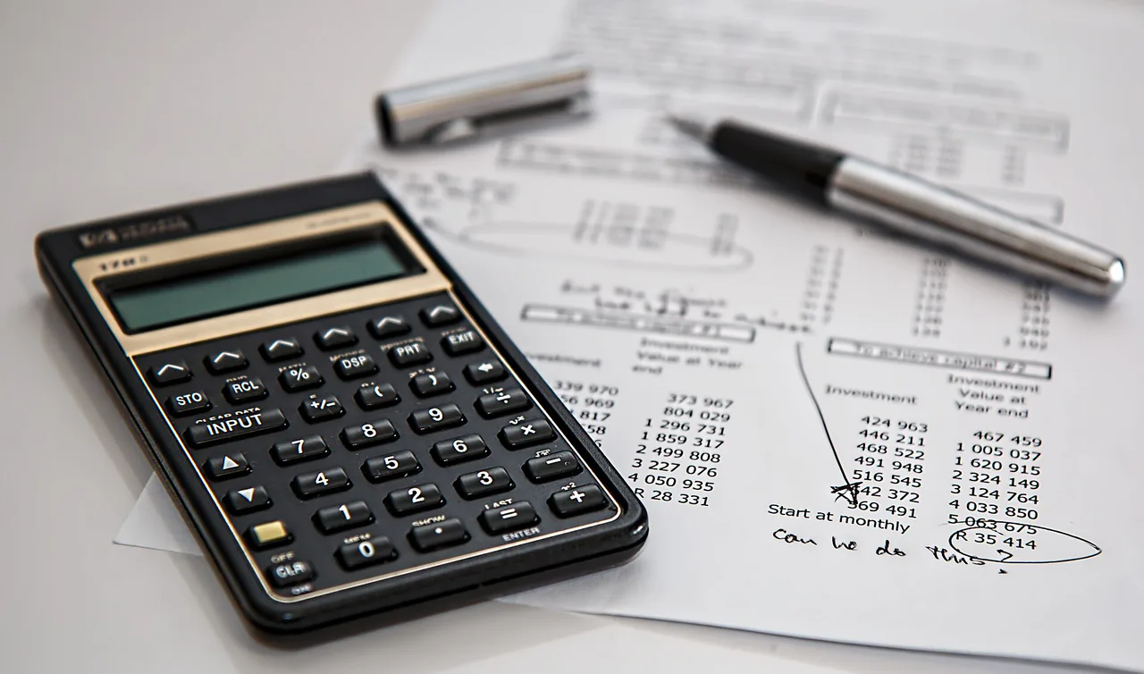 Calculadora y bolígrafo sobre documentos con cifras