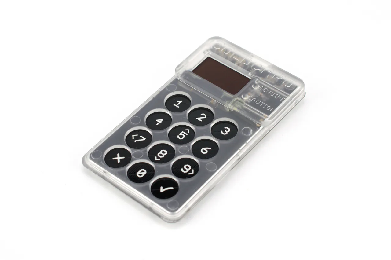 Un dispositivo Coldcard de carcasa transparente muestra su pantalla y teclado numérico.