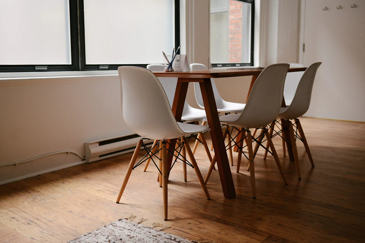 Mesa de madera y sillas junto a una ventana