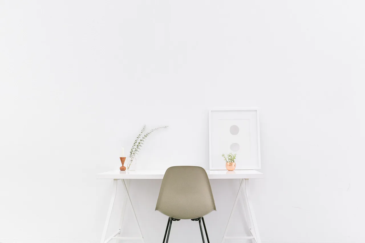 Mesa de trabajo y silla delante de una pared blanca