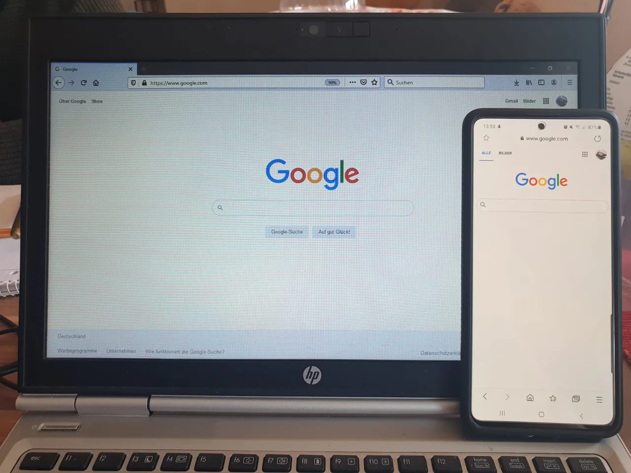 Página de inicio de Google abierta en un portátil y un teléfono móvil