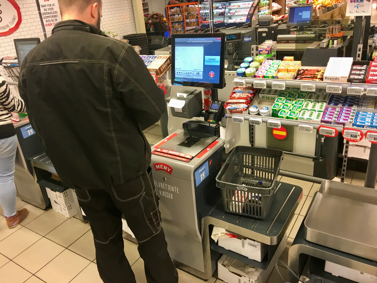 Self-checkout with barcode scanner, screen and basket at a Meny supermarket