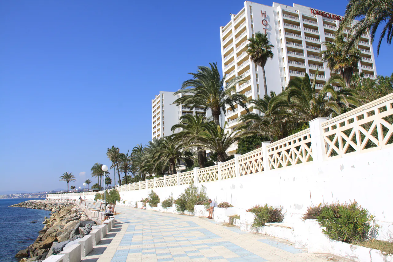 Hotel Torrequebrada beside the Benalmádena seafront promenade, with palm trees and white buildings