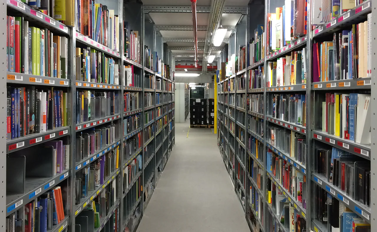 Books stored on shelves with labelled locations inside a logistics centre