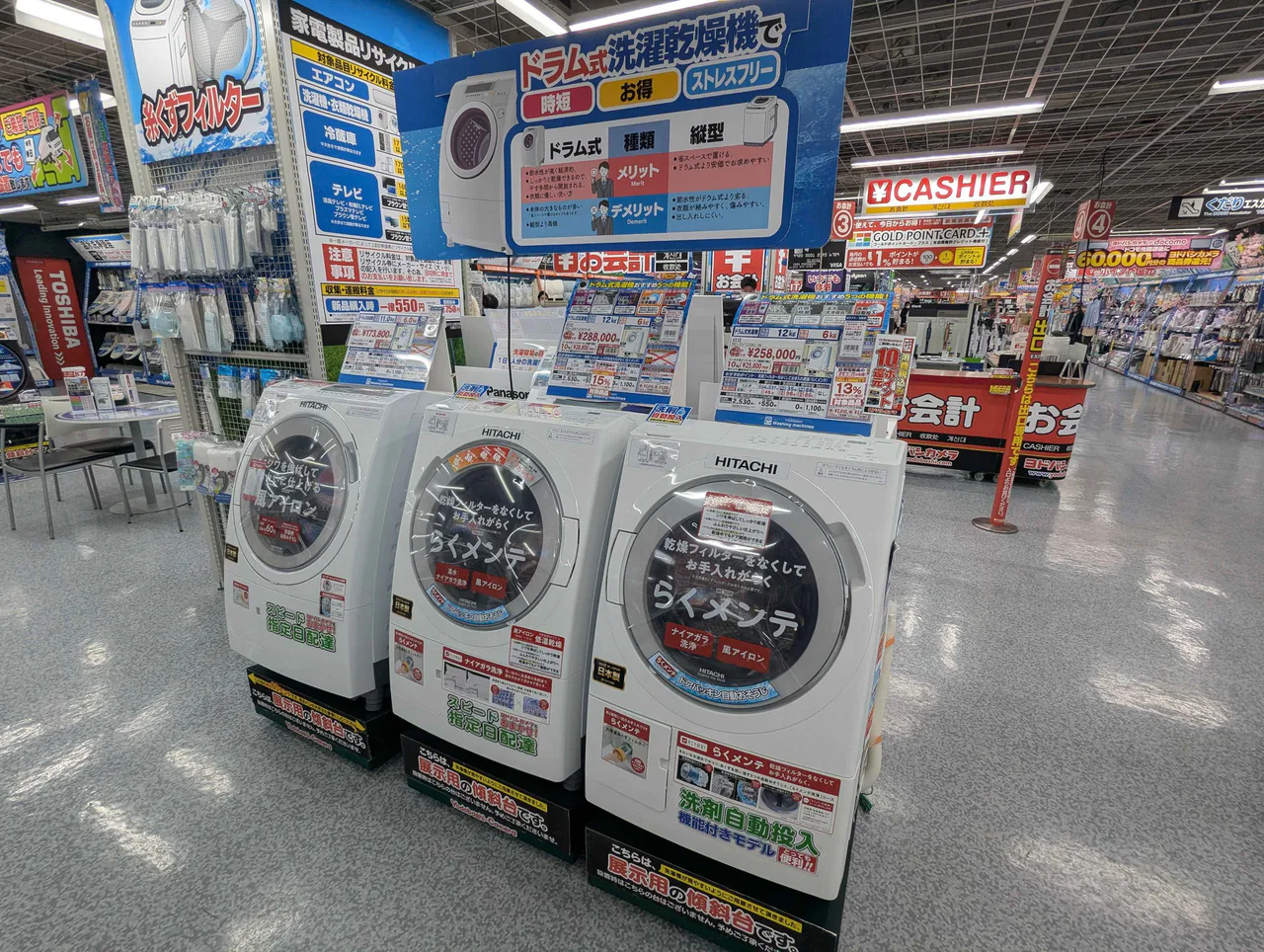 Front-loading Hitachi washing machines displayed in a Japanese electronics store