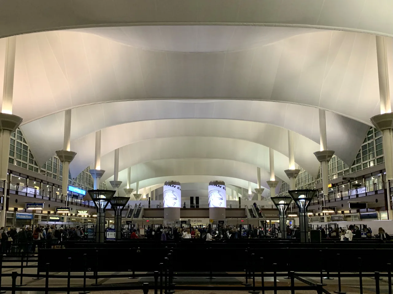 Pasajeros esperan entre las cintas de la fila de seguridad bajo la cubierta del aeropuerto de Denver.