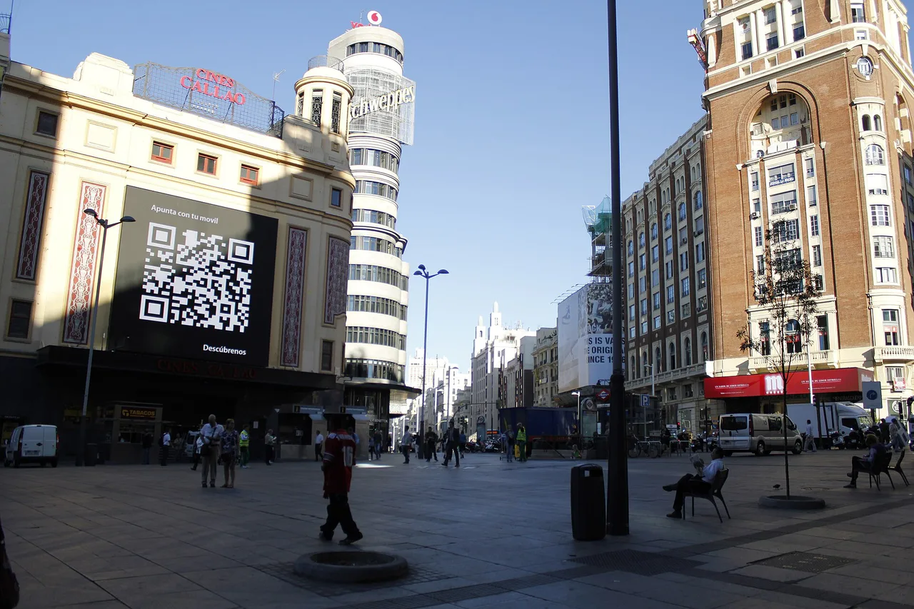 Una pantalla exterior muestra un código QR en la fachada de los Cines Callao de Madrid.
