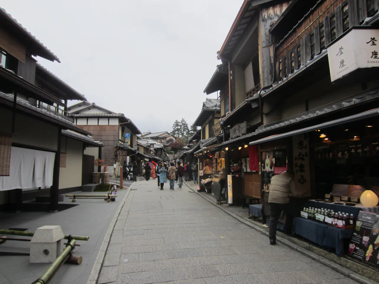 People walk between shops and traditional buildings in Ninen-zaka, Kyoto.