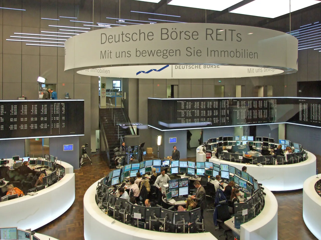 Traders work at clusters of monitors beneath quotation boards on the Frankfurt Stock Exchange floor.