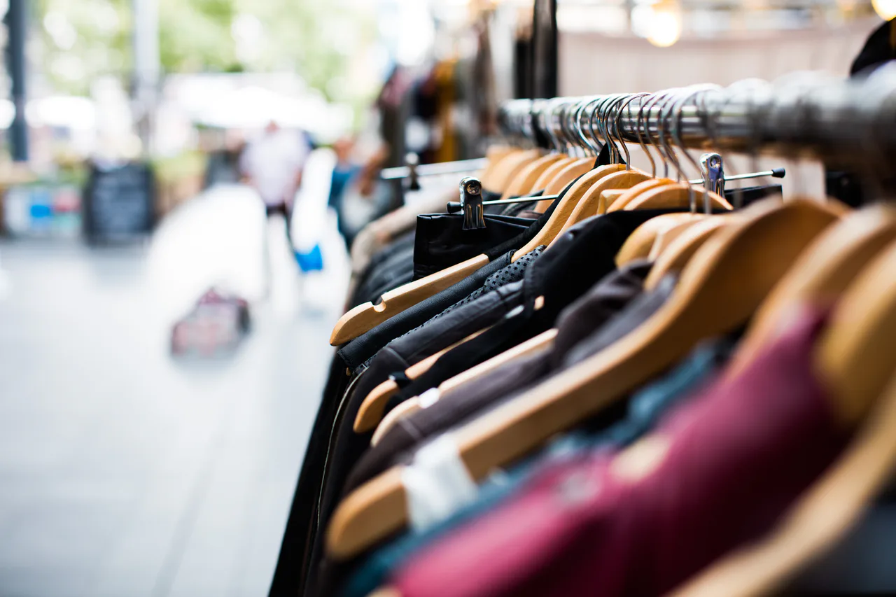 Prendas de ropa en perchas alineadas sobre una barra en una tienda