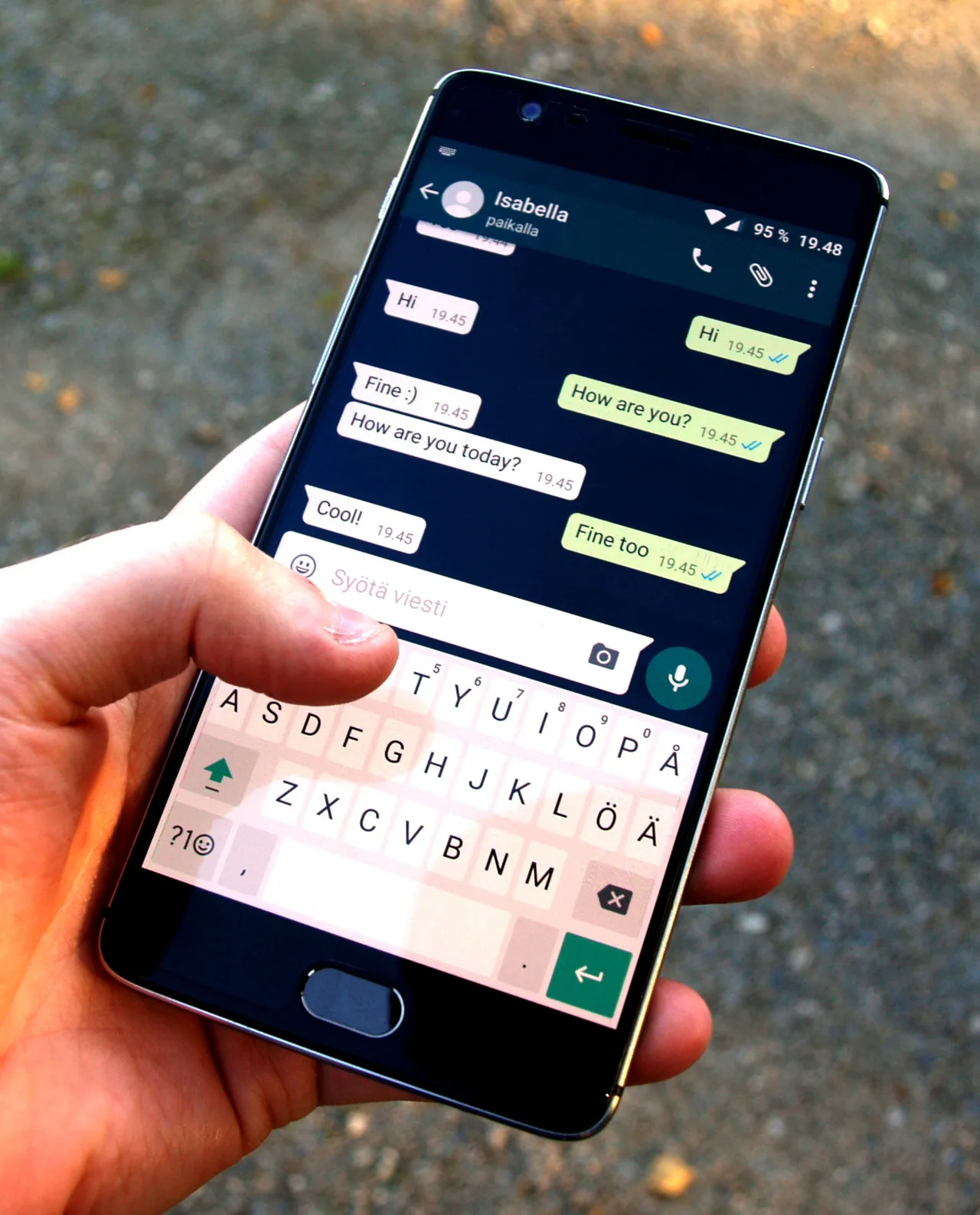 A hand types in a WhatsApp conversation on a phone.