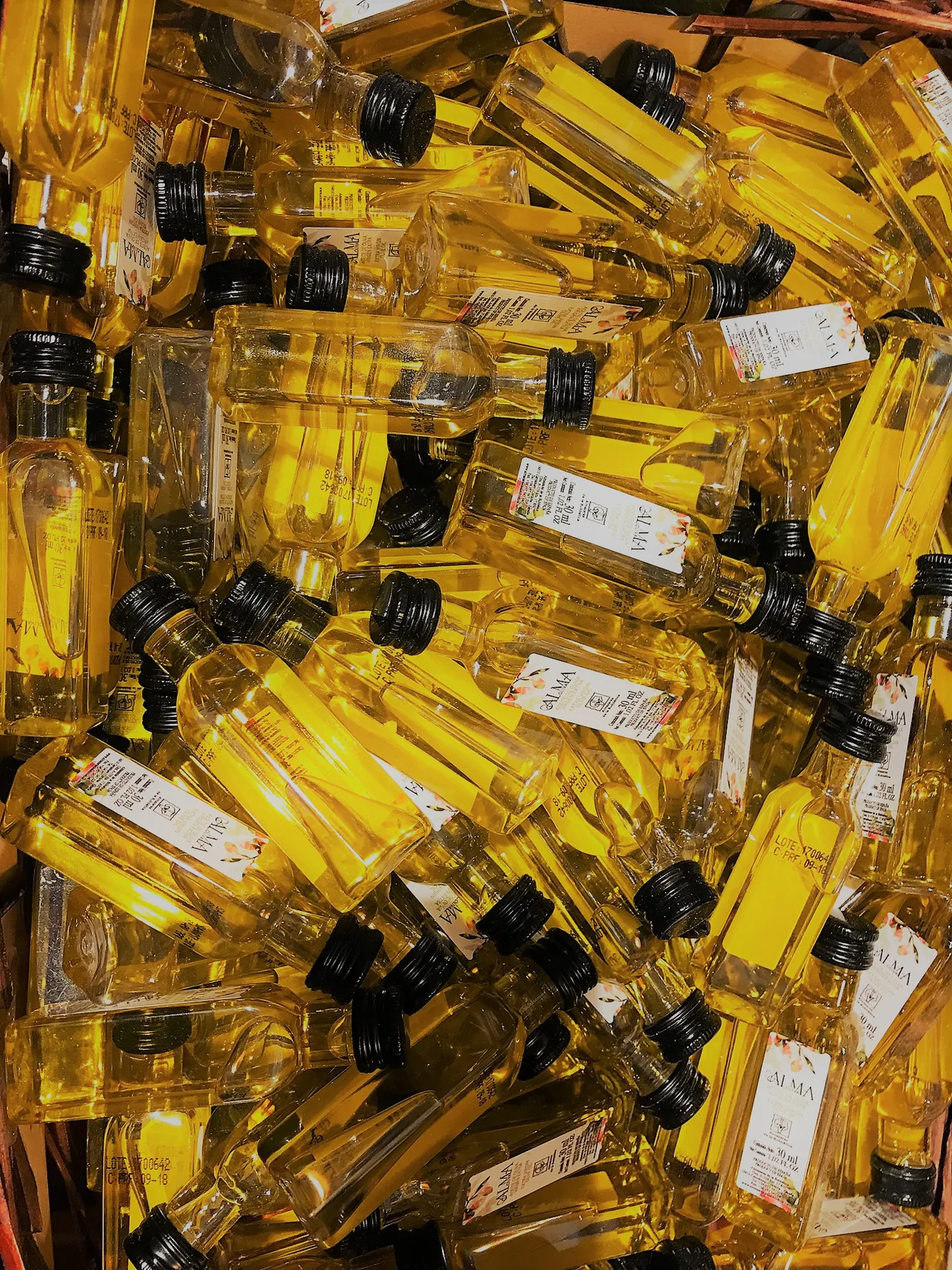 Pequeñas botellas de vidrio con aceite de oliva y tapones negros
