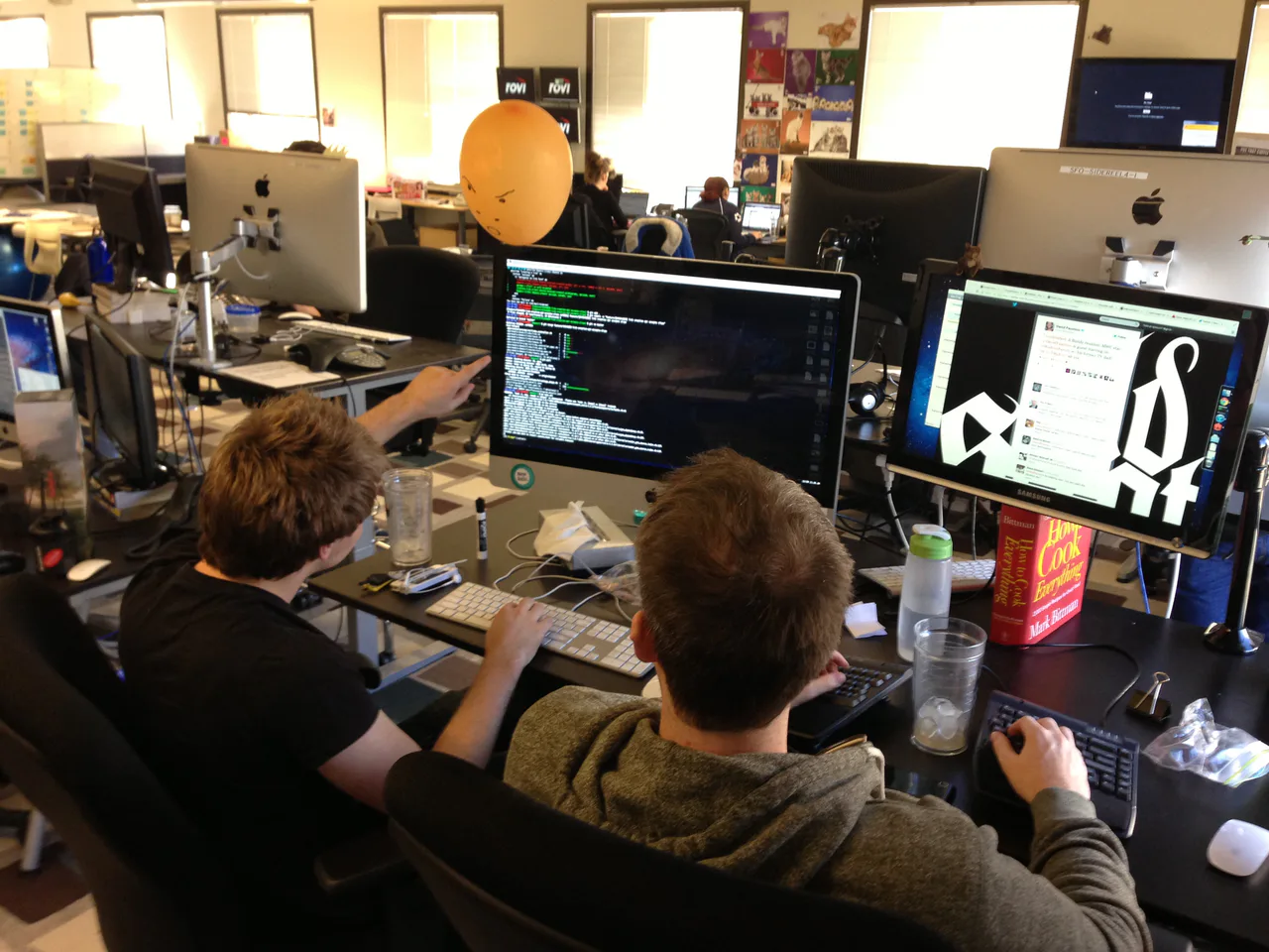 Dos personas revisan código en una pantalla durante una sesión de programación en pareja.