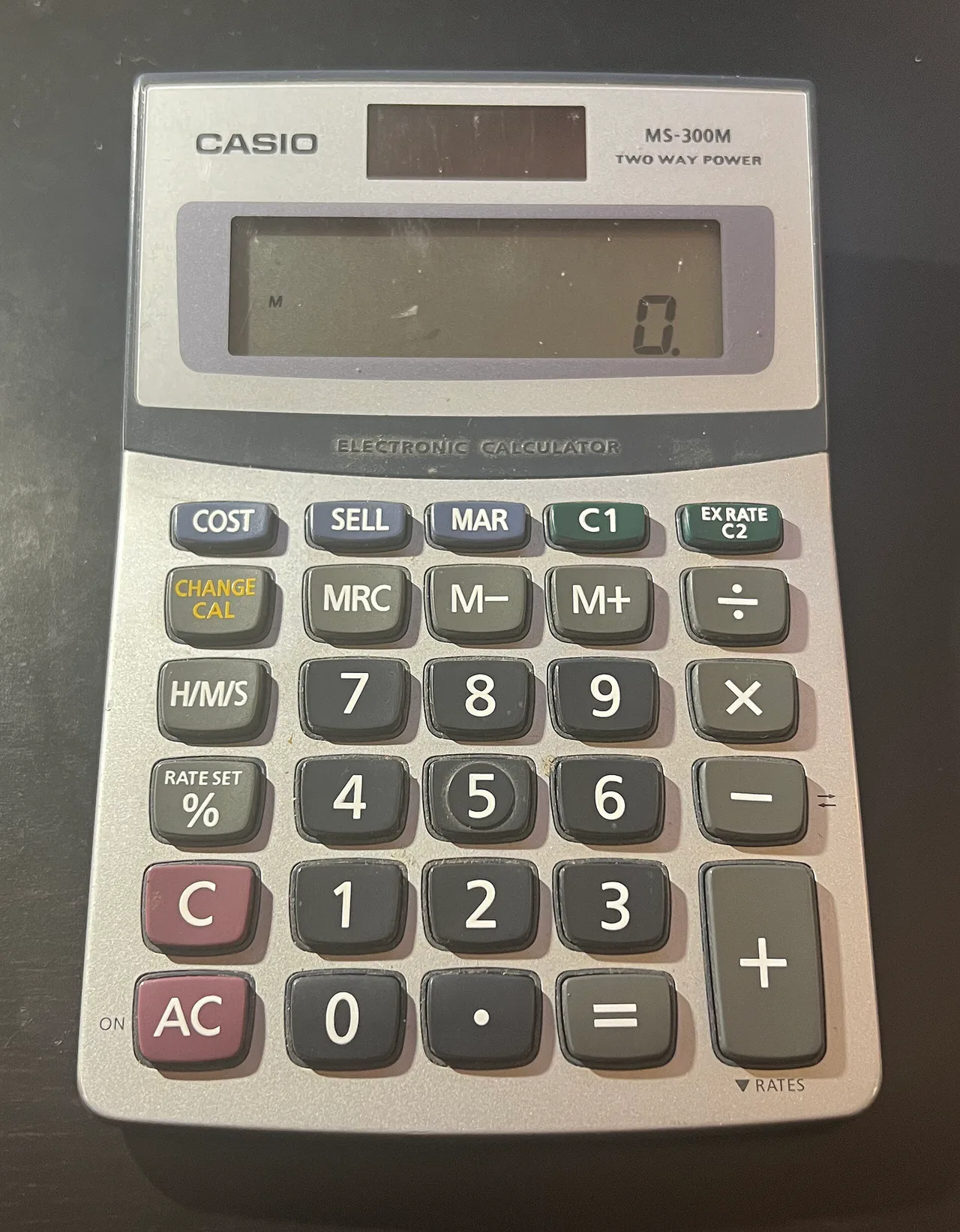 Una calculadora Casio MS-300M gris muestra un cero en la pantalla.