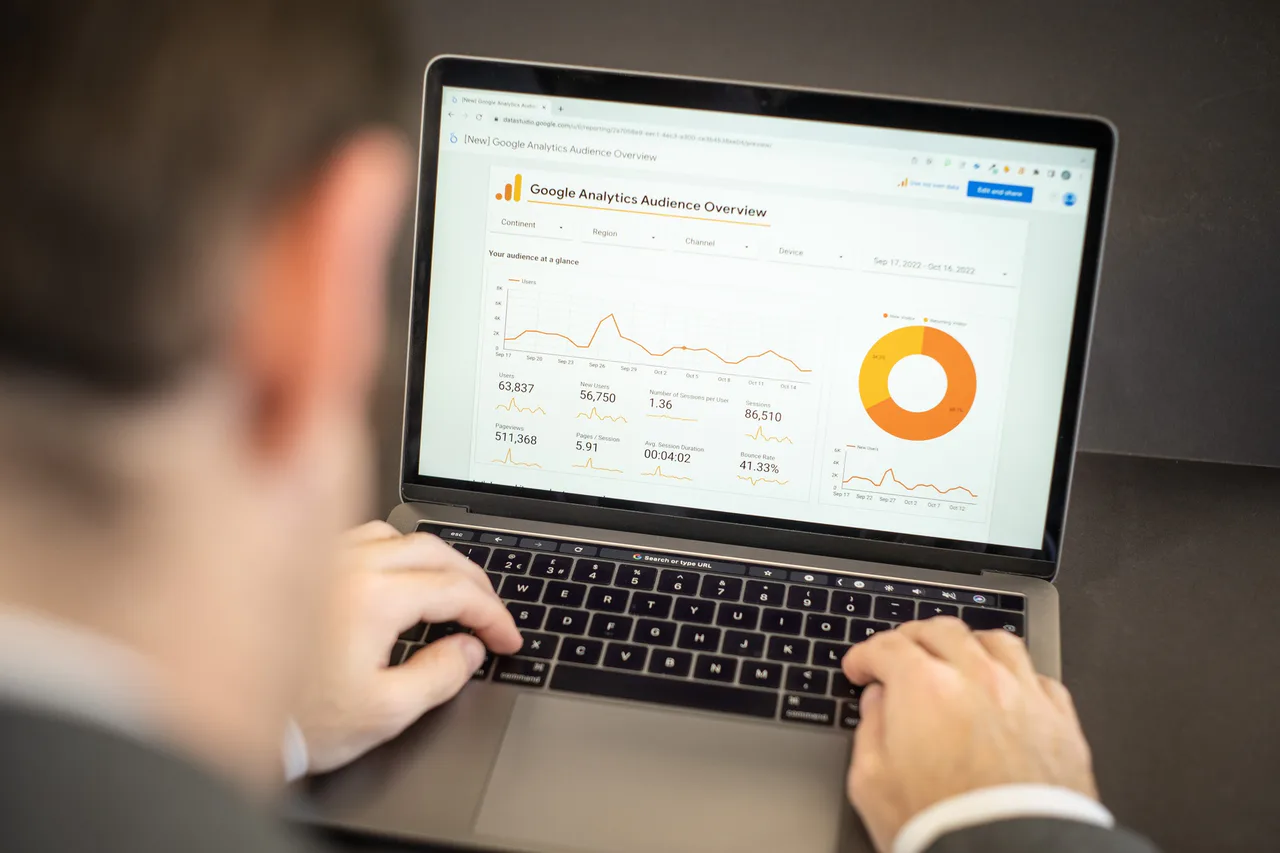 A person examines a Google Analytics audience report on a laptop.