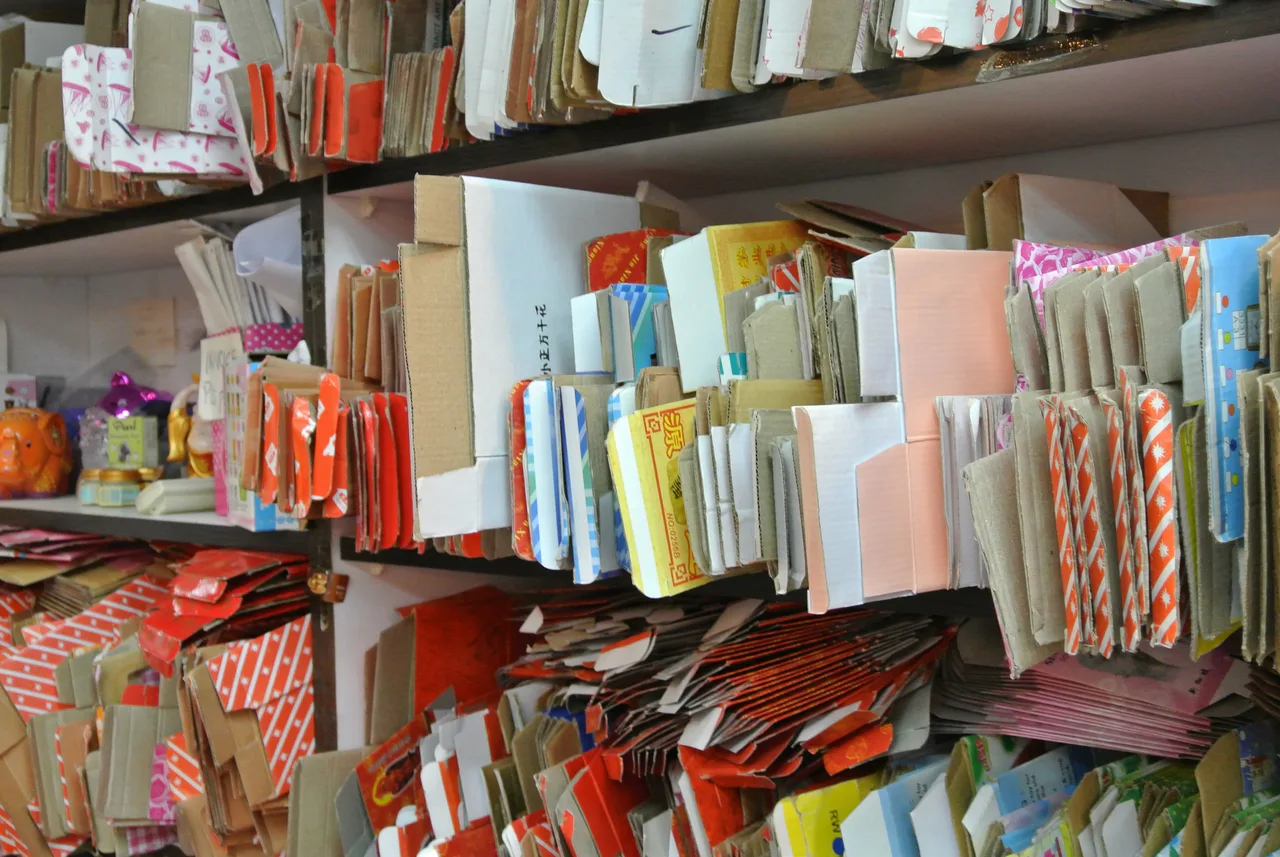 Shelves holding paper bags, boxes and other packaging in several colours.