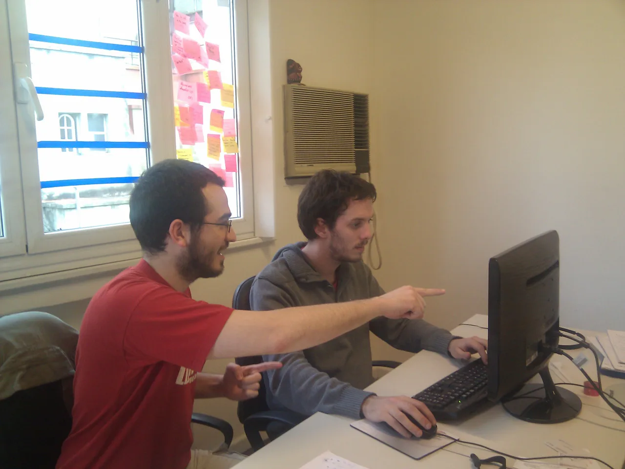 Dos personas trabajan juntas ante una pantalla de ordenador.